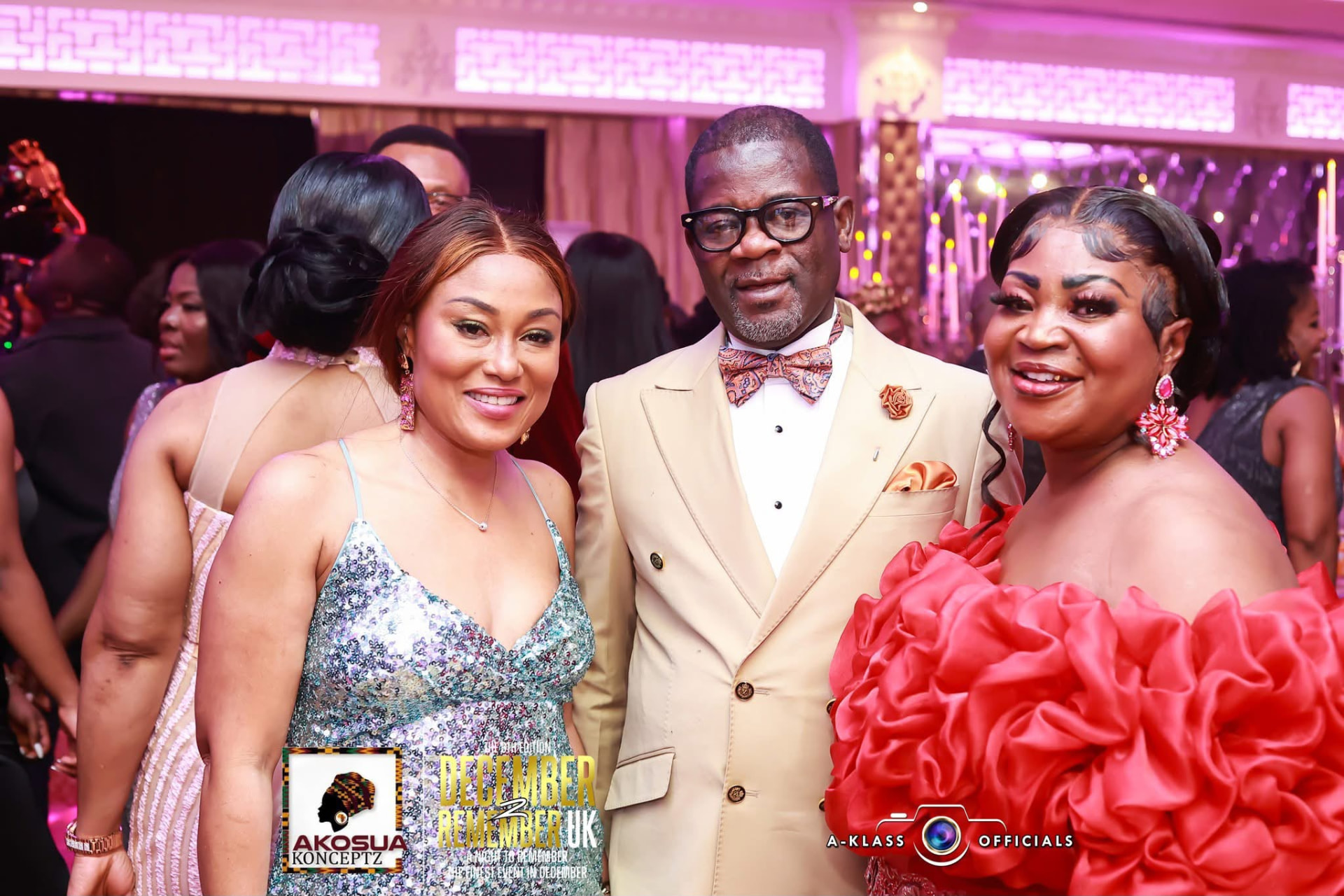 Three guests in cream, silver and red evening wear posing together