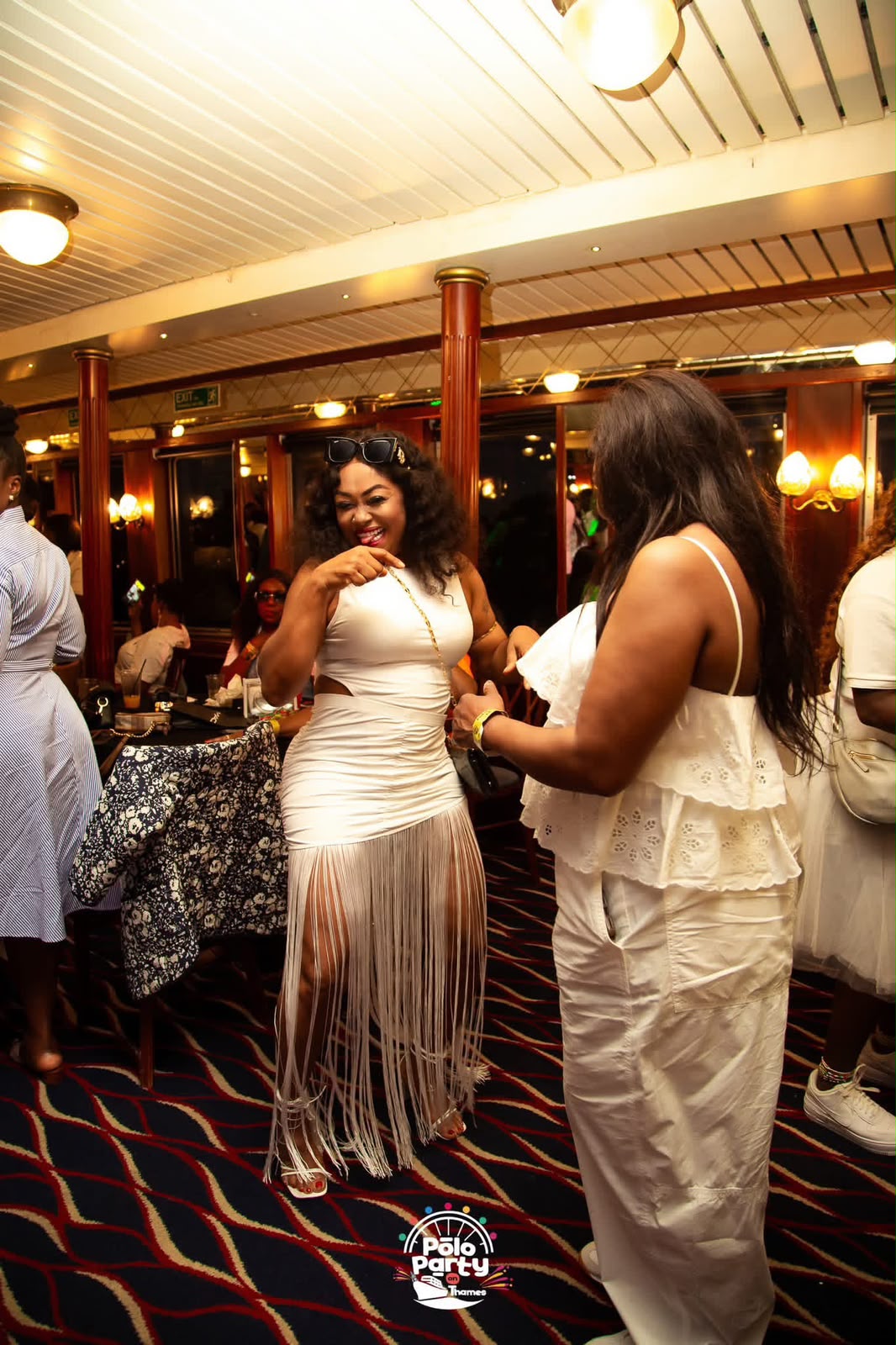 Two guests dancing by the windows with the riverside behind them