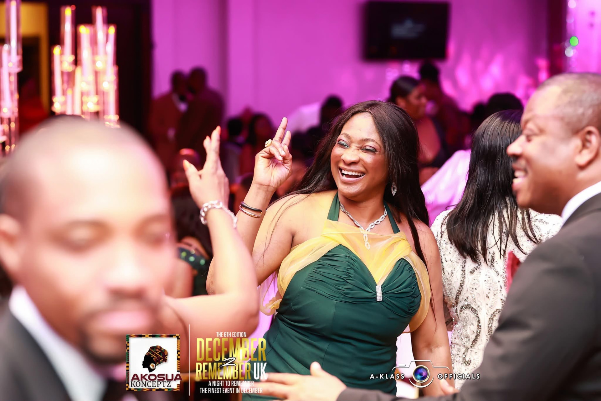Guest in an emerald dress dancing with hands raised
